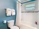 Bathroom featuring toilet and shower with curtain and dark blue accent wall at 714 W Peninsular St, Tampa, FL 33603