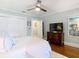 A bedroom features a ceiling fan, white bedding, and hardwood floors at 714 W Peninsular St, Tampa, FL 33603