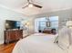 Bright bedroom with hardwood floors, ceiling fan, and an open doorway leading to a sitting area at 714 W Peninsular St, Tampa, FL 33603
