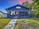 Charming blue two-story home with a manicured front yard, inviting porch, and convenient carport at 714 W Peninsular St, Tampa, FL 33603
