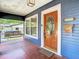 Inviting front porch with a decorative door, outdoor seating, and a hanging swing for relaxing outdoors at 714 W Peninsular St, Tampa, FL 33603