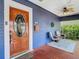 Charming covered porch with seating, a decorative wreath, and a stylish rug, creating an inviting outdoor space at 714 W Peninsular St, Tampa, FL 33603