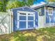 Charming backyard storage shed with double doors and a blue exterior, complementing the main house at 714 W Peninsular St, Tampa, FL 33603