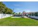 Spacious backyard showcasing a fenced pool, patio area with seating, and lush green lawn at 731 44Th Ne Ave, St Petersburg, FL 33703