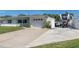 Well-maintained single-story home with a white exterior, garage, driveway, and RV parking on a sunny day at 731 44Th Ne Ave, St Petersburg, FL 33703