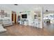 Open-concept living room with a modern entertainment center, neutral colors, and wood-look tile floors at 731 44Th Ne Ave, St Petersburg, FL 33703