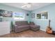 Bright living room with a comfortable grey sofa, light blue walls, and wood-look tile flooring at 731 44Th Ne Ave, St Petersburg, FL 33703