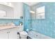 Stylish blue-tiled bathroom with glass-enclosed shower and modern fixtures at 747 39Th Ne Ave, St Petersburg, FL 33703