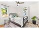 A cozy bedroom with a black iron bed frame, large windows, and tropical-themed decor at 747 39Th Ne Ave, St Petersburg, FL 33703