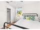 Bright bedroom with hardwood floors, a black metal bed frame, a closet, and a large window for natural light at 747 39Th Ne Ave, St Petersburg, FL 33703