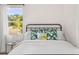 Bright bedroom featuring an iron bed frame and tropical-themed throw pillows near a sunny window at 747 39Th Ne Ave, St Petersburg, FL 33703