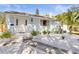 Inviting single-story home with light blue exterior, landscaped with white gravel, plants, and a concrete walkway to the front door at 747 39Th Ne Ave, St Petersburg, FL 33703