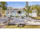 Charming single-story home with a light blue exterior, complemented by modern landscaping with white gravel and a walkway at 747 39Th Ne Ave, St Petersburg, FL 33703