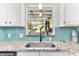 Bright kitchen with stainless steel sink, granite countertops, stylish backsplash and view from window at 747 39Th Ne Ave, St Petersburg, FL 33703
