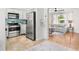 Open concept kitchen and living area with stainless appliances, hardwood floors, and beachy decor at 747 39Th Ne Ave, St Petersburg, FL 33703