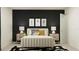 Chic bedroom with a luxurious bed, unique bedside tables, dark accent wall, and elegant modern decor at 8108 Painted Sky Pl, Land O Lakes, FL 34637