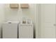 Bright laundry room with a white washer, dryer, and shelving at 8108 Painted Sky Pl, Land O Lakes, FL 34637