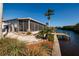 Backyard with a view of a canal, palm trees, and a waterfront patio and deck at 9409 Sun Isle Ne Dr, St Petersburg, FL 33702