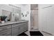 Well-lit bathroom with gray cabinets, granite counters, and shower at 9409 Sun Isle Ne Dr, St Petersburg, FL 33702