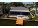 Aerial view of canal-front home featuring a new roof, screened in porch, and private dock at 9409 Sun Isle Ne Dr, St Petersburg, FL 33702