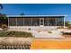 Rear of home featuring an enclosed patio with brick and gravel landscaping at 9409 Sun Isle Ne Dr, St Petersburg, FL 33702