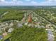 Aerial view of the community with a home identified by a red arrow amidst lush greenery at 9905 Woodbay Dr, Tampa, FL 33626