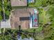 Aerial view of home with screened pool, solar panels, and well-maintained landscaping at 9905 Woodbay Dr, Tampa, FL 33626