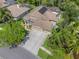 Aerial view showcasing a home with a well-maintained yard, mature trees, and a spacious driveway at 9905 Woodbay Dr, Tampa, FL 33626