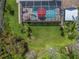 Aerial view of backyard featuring a screened-in pool with umbrellas and ample green space at 9905 Woodbay Dr, Tampa, FL 33626