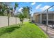 Spacious backyard with a well-maintained lawn, mature trees, and a privacy fence at 9905 Woodbay Dr, Tampa, FL 33626
