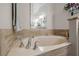 Luxurious bathroom featuring a soaking tub with tile surround and modern faucets at 9905 Woodbay Dr, Tampa, FL 33626