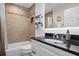 Tiled bathroom featuring a vanity with a black countertop, built-in shelving, and updated fixtures at 9905 Woodbay Dr, Tampa, FL 33626