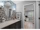 Stylish bathroom featuring a mosaic tile wall, oval mirror, and open doorway to a home office at 9905 Woodbay Dr, Tampa, FL 33626