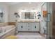 Modern bathroom with double vanity, soaking tub, and glass-enclosed shower, offering a spa-like experience at 9905 Woodbay Dr, Tampa, FL 33626