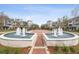 Serene community fountain with symmetrical landscaping and blue and white condo buildings at Avalon at Pine Ridge at 9905 Woodbay Dr, Tampa, FL 33626