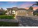 Charming home with a three-car garage and manicured lawn, beautifully lit at dusk at 9905 Woodbay Dr, Tampa, FL 33626