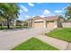 Spacious home featuring a three-car garage, a long driveway, and verdant lawn at 9905 Woodbay Dr, Tampa, FL 33626