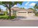 Charming one-story home with a three-car garage, landscaped front yard, and a covered entryway at 9905 Woodbay Dr, Tampa, FL 33626