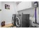 Well-equipped laundry room featuring a washer, dryer, storage cabinets, and cleaning supplies at 9905 Woodbay Dr, Tampa, FL 33626