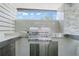 Modern outdoor kitchen featuring a stainless steel grill and elegant stone countertops at 9905 Woodbay Dr, Tampa, FL 33626