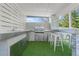 A well-appointed outdoor kitchen boasts a stainless steel grill, sink, bar seating, and artificial turf at 9905 Woodbay Dr, Tampa, FL 33626