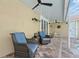 Outdoor patio area with two blue cushioned chairs and ceiling fans, ideal for comfortable outdoor living at 9905 Woodbay Dr, Tampa, FL 33626