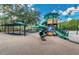 Community playground featuring a large play structure with slides and covered swing sets at 9905 Woodbay Dr, Tampa, FL 33626
