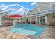A screened-in pool and patio featuring an umbrella and a fire pit are surrounded by lush landscaping at 9905 Woodbay Dr, Tampa, FL 33626