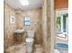 Bathroom with sink, toilet, and tile, and access to the pool area at 13936 Harbor View Dr, Seminole, FL 33776