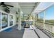 Inviting screened-in porch featuring cozy seating, ceiling fans, and views of lush palm trees at 13936 Harbor View Dr, Seminole, FL 33776