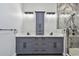 Bathroom featuring double sink vanity with storage and glass enclosed shower at 1045 Jesse Ave, Safety Harbor, FL 34695