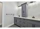 Bathroom featuring dual sinks, gray cabinets, white marble countertop, black hardware, and modern lighting at 1045 Jesse Ave, Safety Harbor, FL 34695