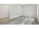 Bright bedroom features gray wood flooring, white walls and trim, and a doorway to an adjacent room at 1045 Jesse Ave, Safety Harbor, FL 34695