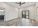 Bedroom features gray wood flooring, ceiling fan, and glass doors leading to balcony at 1045 Jesse Ave, Safety Harbor, FL 34695
